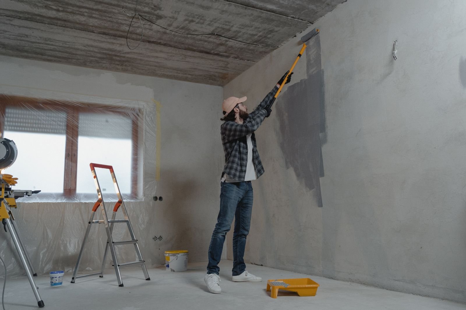 A painter rolling a fresh coat on an interior wall